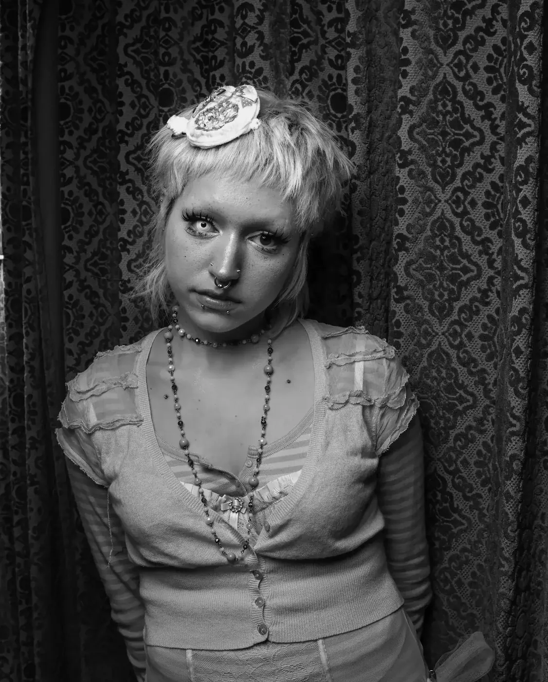 A singer photographed against the gold damask curtain