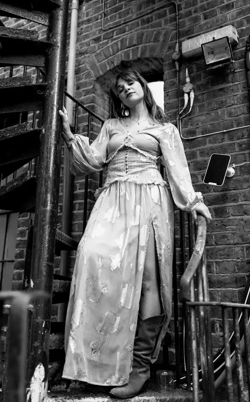 A performer on the iron spiral staircase behind the theatre
