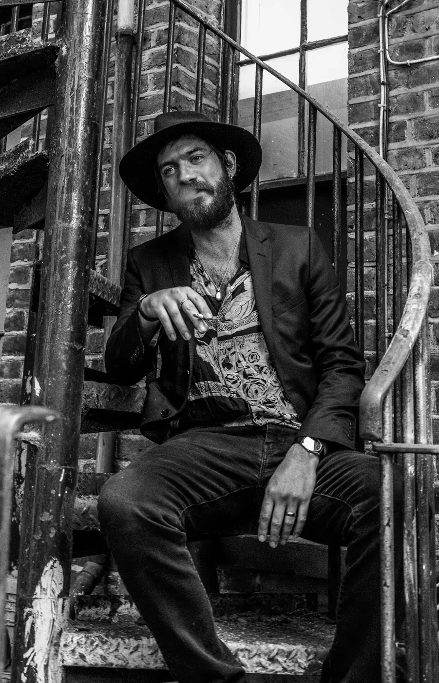 A performer seated on the spiral staircase
